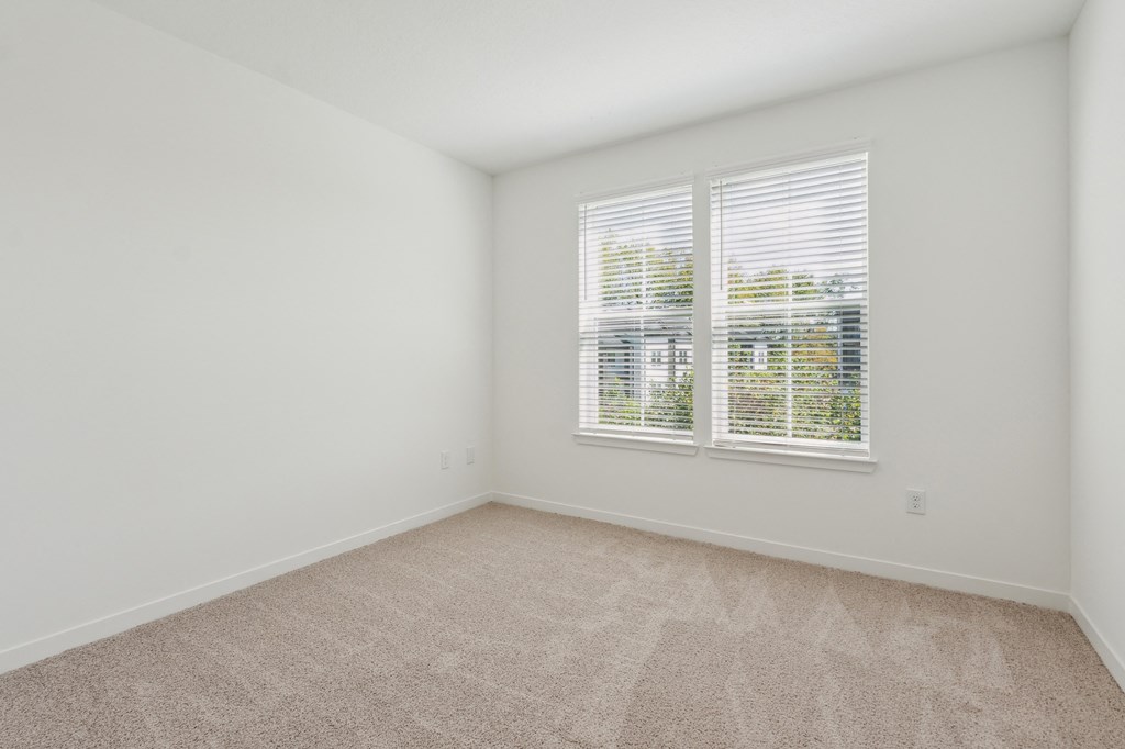 an empty room with white walls and a window