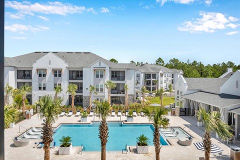 A large white building with a pool in front.
