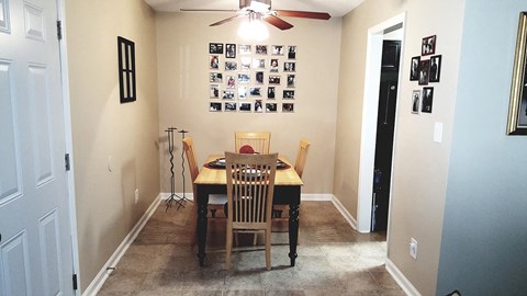 a dining room with a table and chairs and a ceiling fan