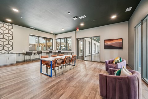A modern dining room with a long table and chairs.