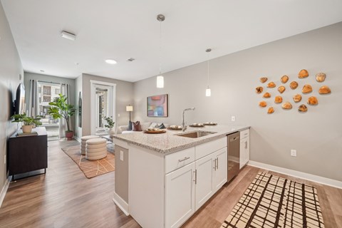 A kitchen with a white counter top and cabinets.