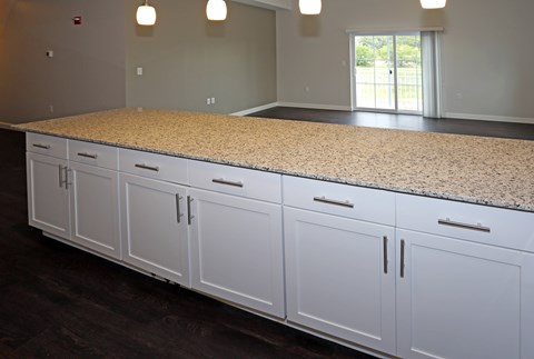 oversized breakfast bar with cabinets, pendant lighting, and granite countertop EV charging stations at Promenade at Founders Square Apartments in Indianapolis, IN