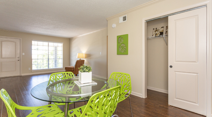 a dining room with a glass table and green chairs