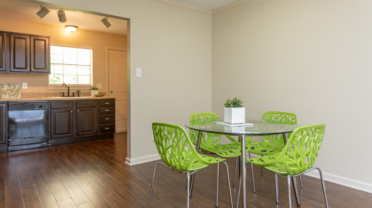 a dining room with green chairs and a glass table