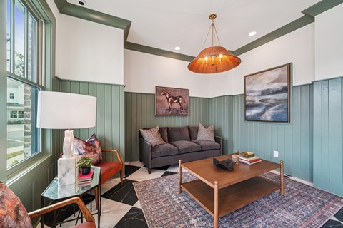 A living room with a grey couch, a coffee table, and a painting on the wall.