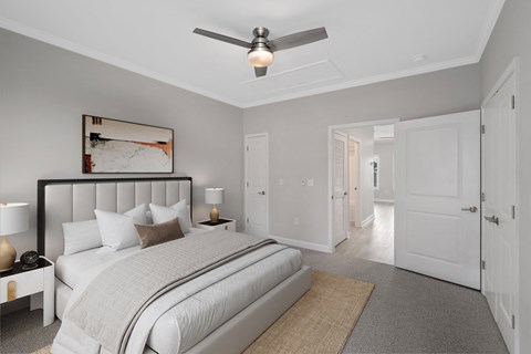 a bedroom with a large bed and a ceiling fan at The Cottages at Foley Farms apartments in Foley, AL