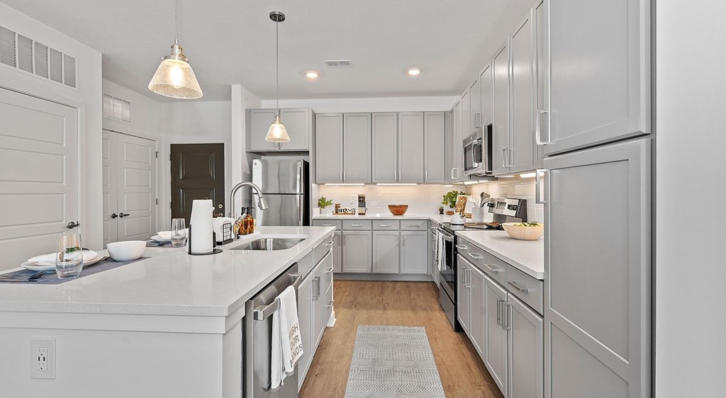 A modern kitchen with white cabinets and a central island.