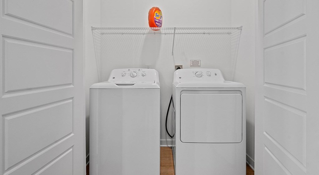 Two white washing machines in a laundry room.
