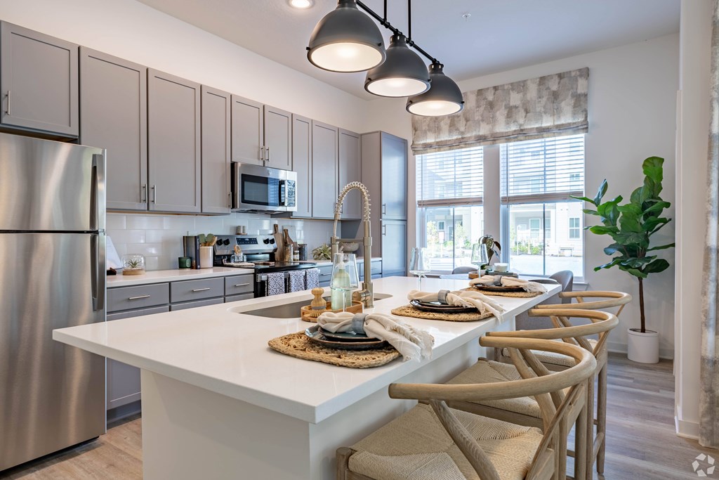 A modern kitchen with a white island and stainless steel appliances.