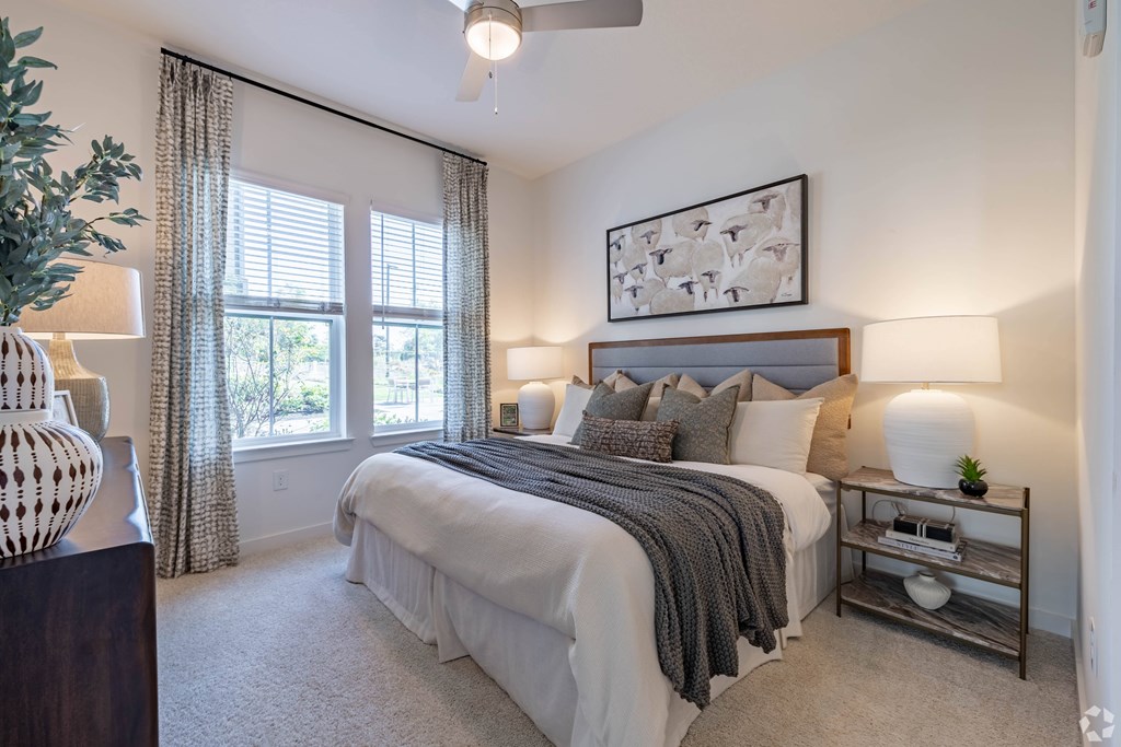 A bedroom with a large bed and a ceiling fan.