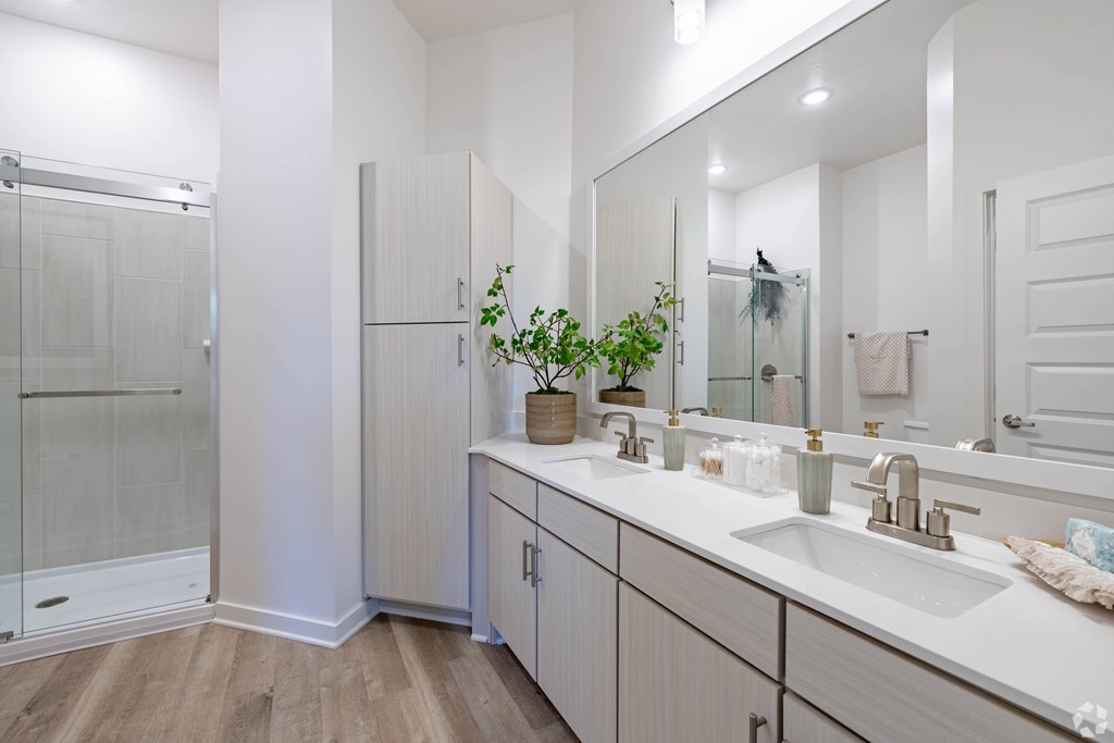 A bathroom with a white sink and a mirror.