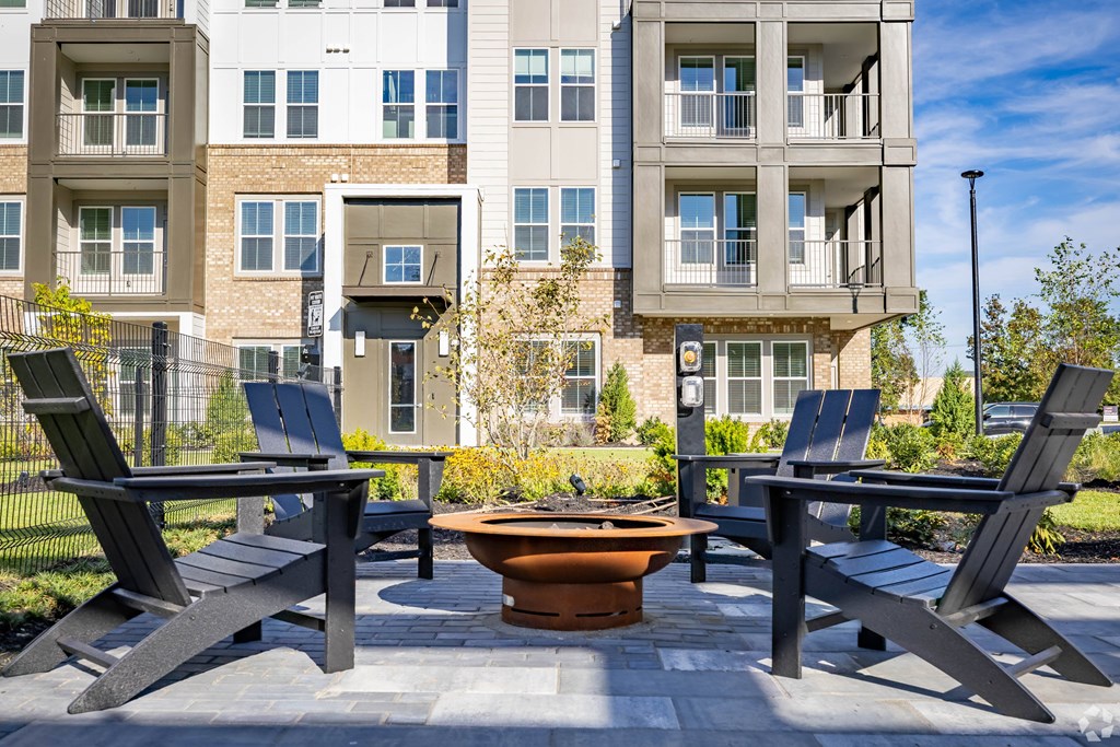 A patio with chairs and a table in front of a building.