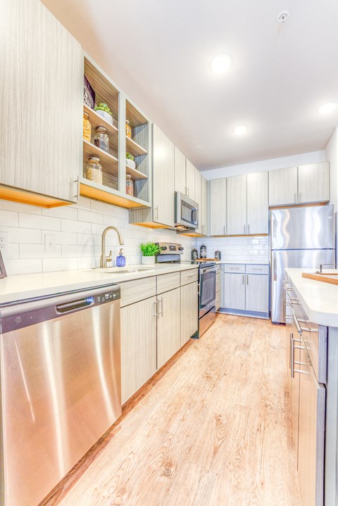 a large kitchen with stainless steel appliances and white cabinets