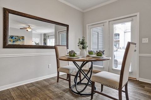 Dining room with plank flooring and fireplace at Village at Caldwell Mill in Birmingham, AL