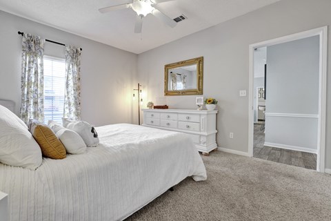 Bedroom with plush carpet and window at Village at Caldwell Mill Apartments in Birmingham, AL