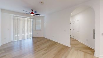 Living room with ceiling fan and private patio access at Wesley Place Apartments in Indianapolis, Indiana