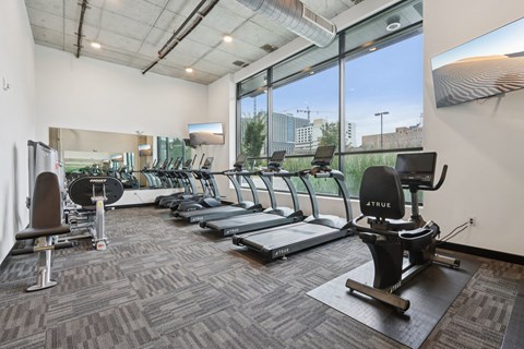 A gym with treadmills, elliptical machines, and other exercise equipment.