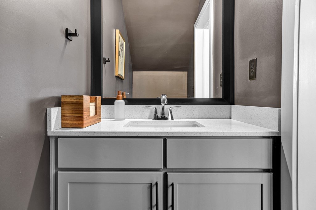 A modern bathroom with a undermount sink, framed mirror, and quartz countertops at West Row Lofts and Townhomes in Birmingham, AL.