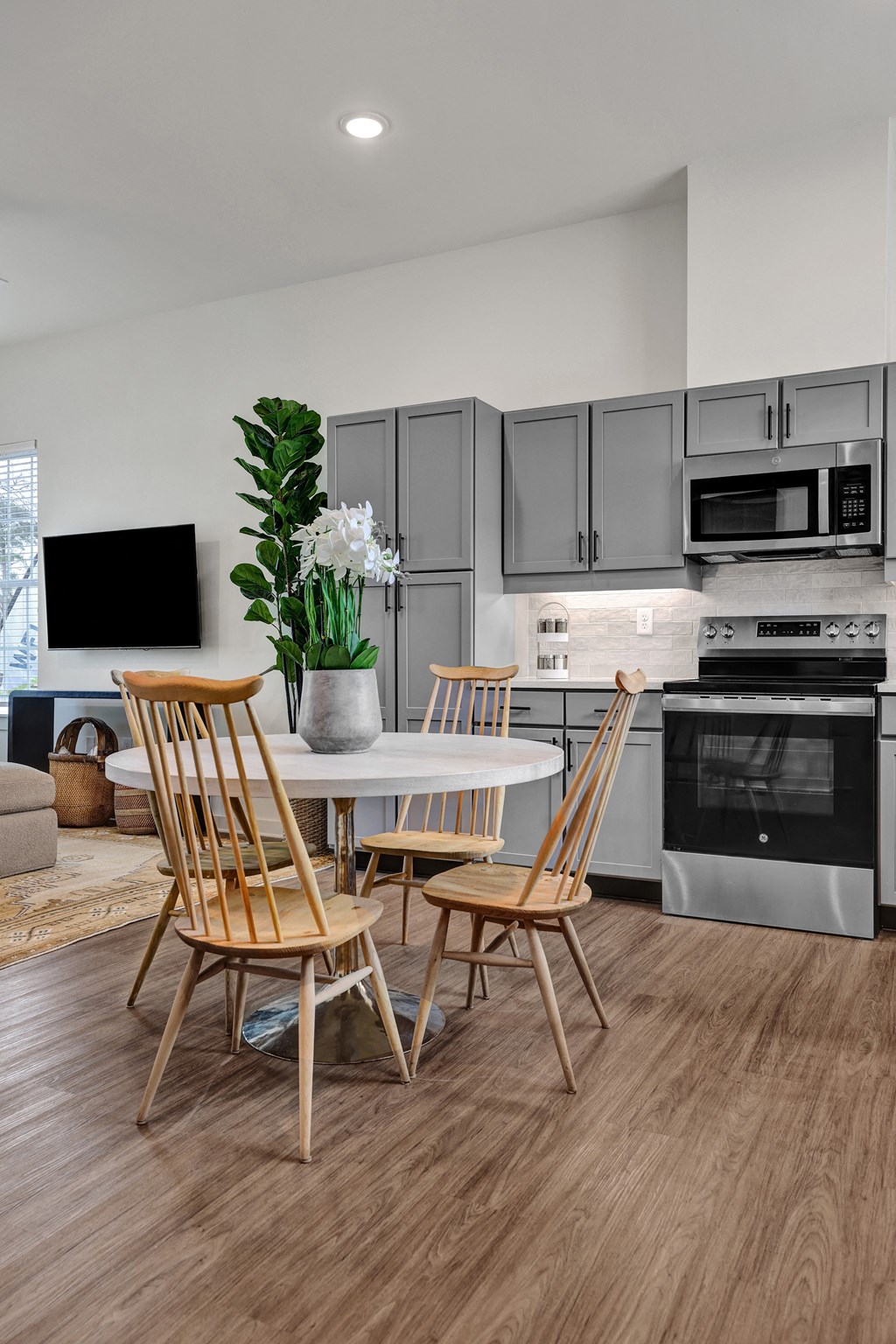 A modern kitchen with plank flooring, stainless steel appliances and custom cabinetry at West Row Lofts and Townhomes in Birmingham, AL