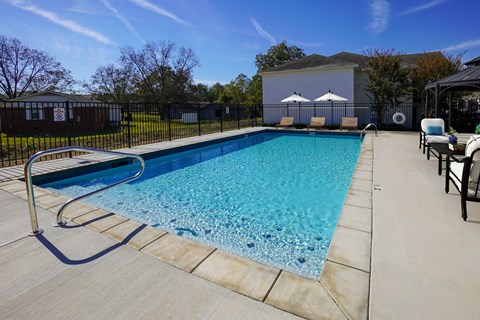 A swimming pool with a slide and a chair.