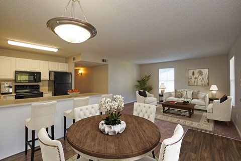 A modern dining room with a wooden table and white chairs.