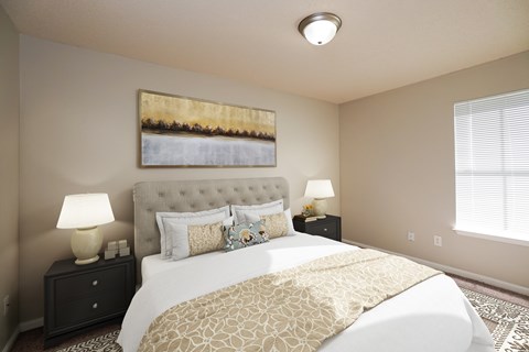 A bedroom with a large bed and a painting on the wall.