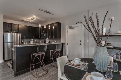 a kitchen and dining room with stainless steel appliances and a table and chairs