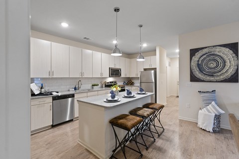 an open kitchen with an island and stools in front of a kitchen counter top