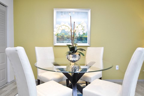 a dining room with a glass table and white chairs