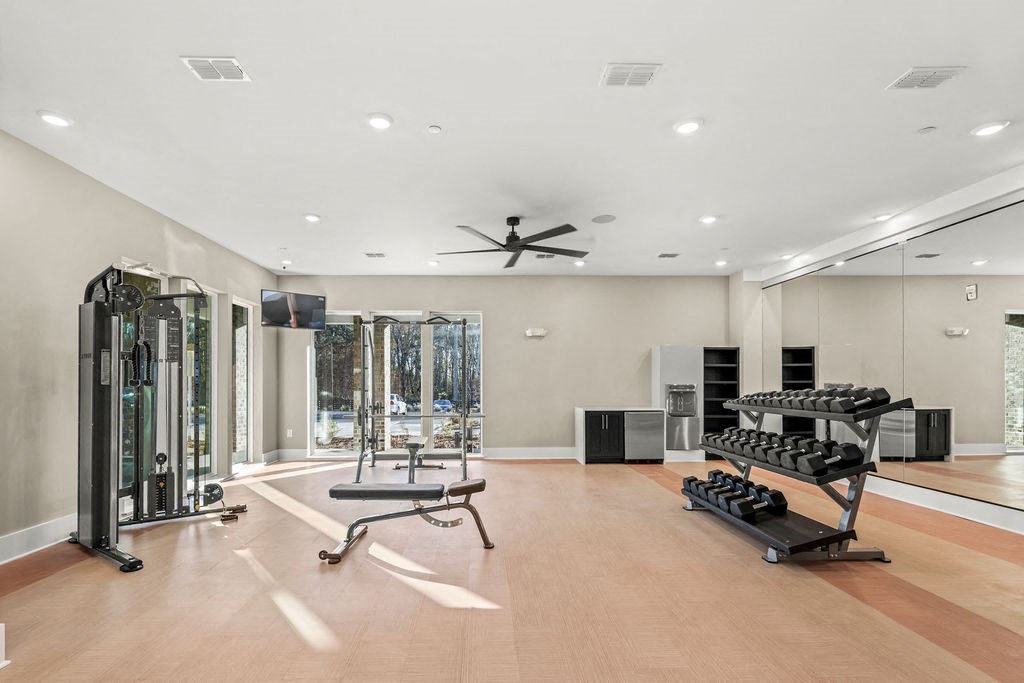 the home gym has a mirrored wall and a floor to ceiling window