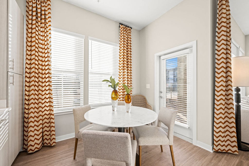 a dining room with a table and chairs and windows