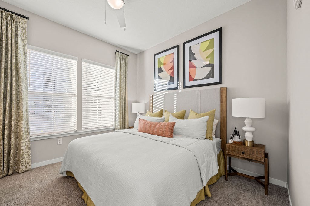 a bedroom with a large bed and windows