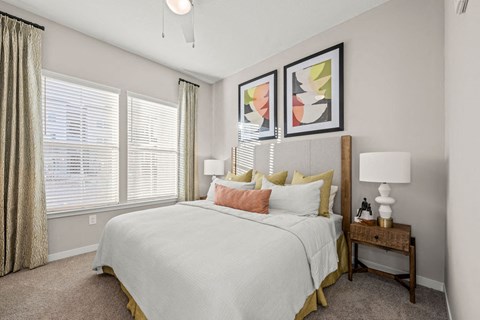 a bedroom with a large bed and windows