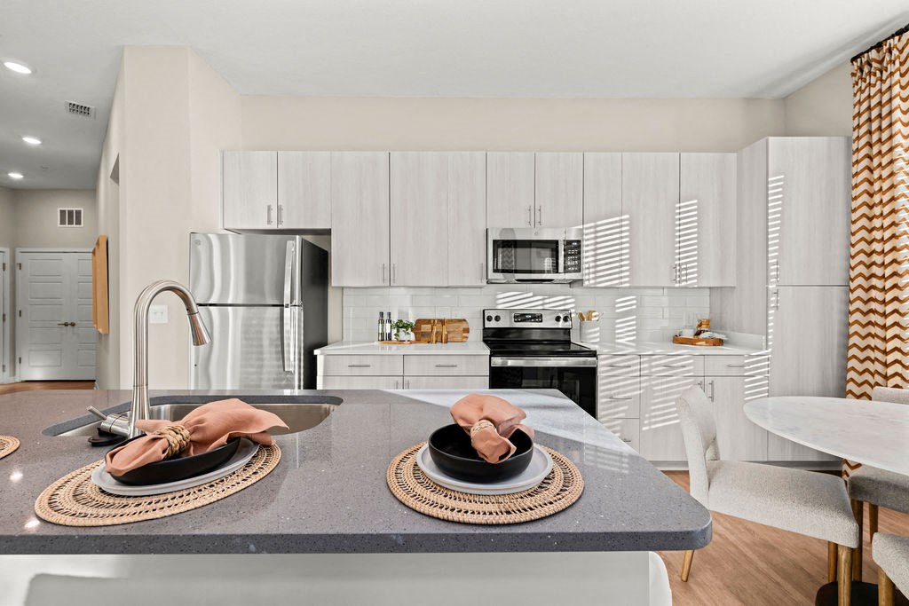 a kitchen with a sink and a counter with plates on it