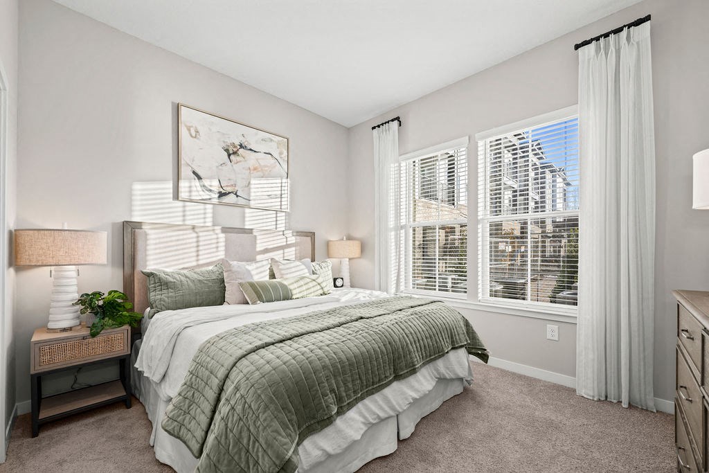 a bedroom with a bed and two windows