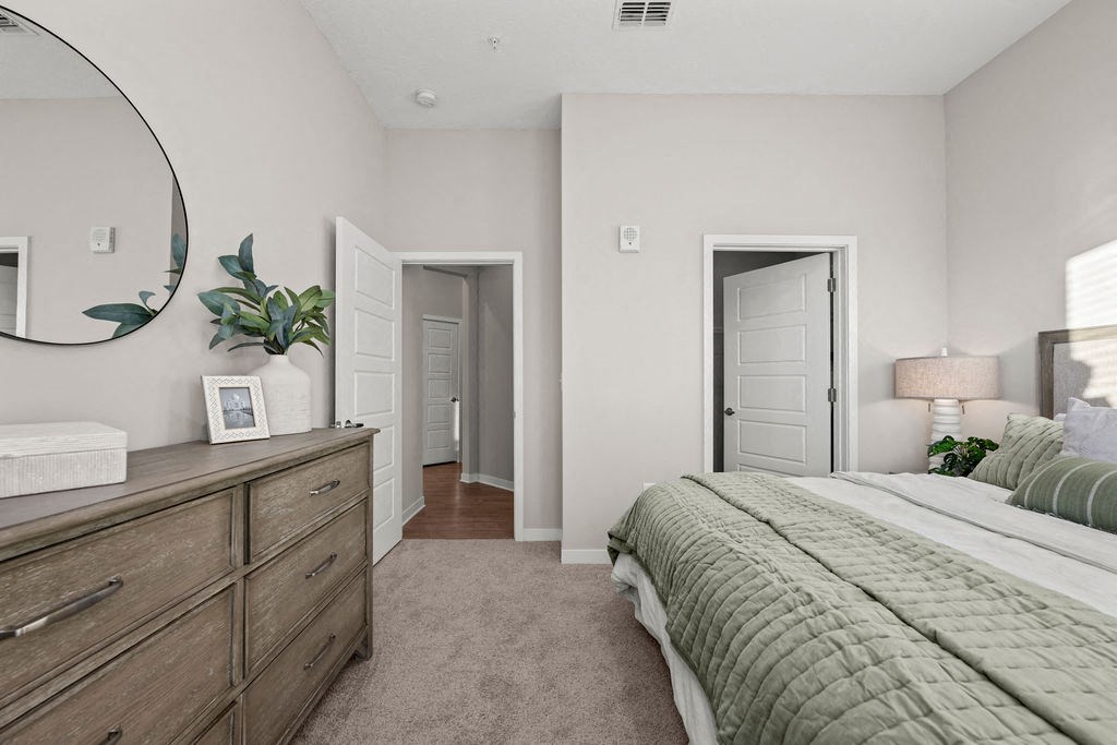 a bedroom with a large bed and a mirror