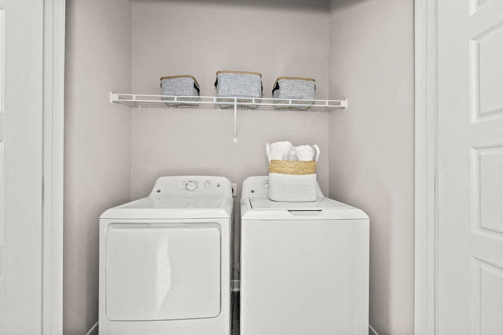 a white washer and dryer in a laundry room with a white door