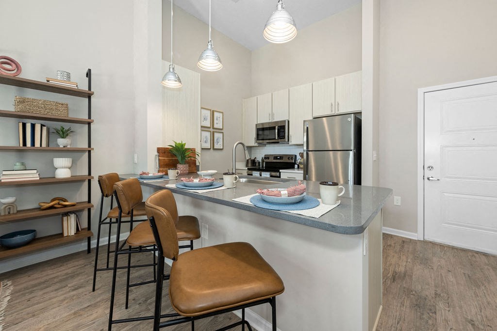 a kitchen with an island and stools in front of a counter top
