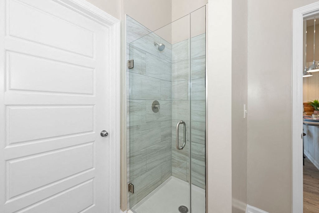 a bathroom with a shower and a white door