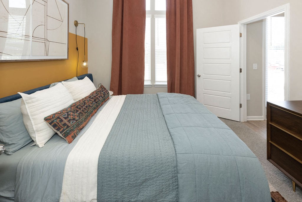 a bedroom with a bed and two windows