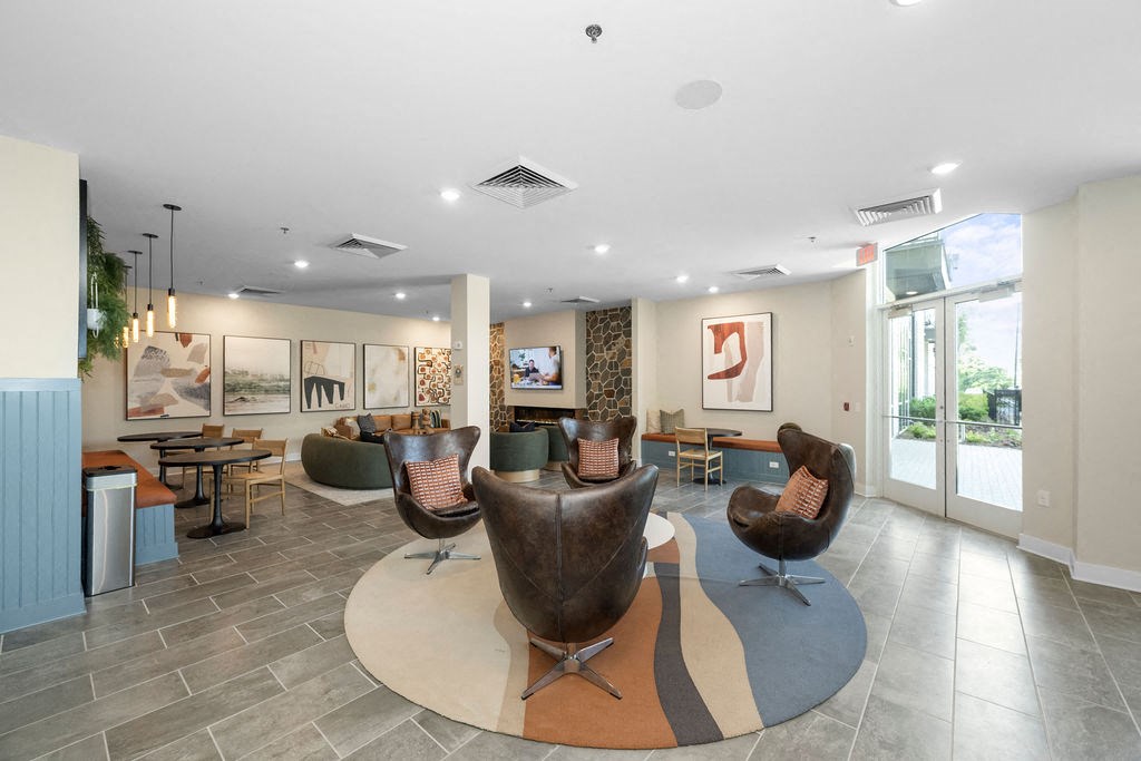 a lobby with chairs and tables and a large window