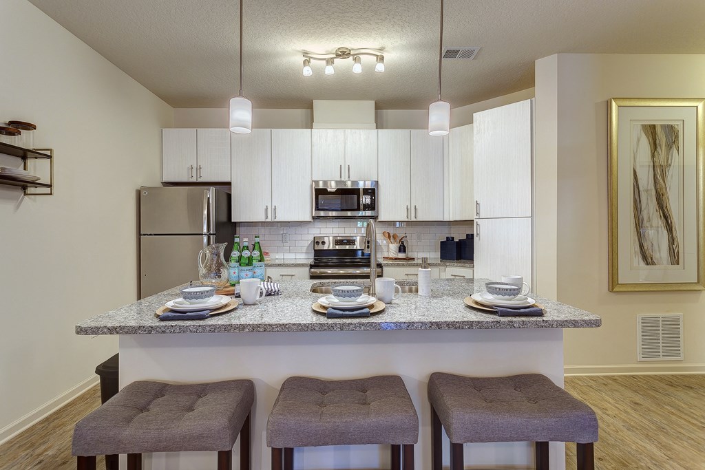 a kitchen with a granite counter top with three stools