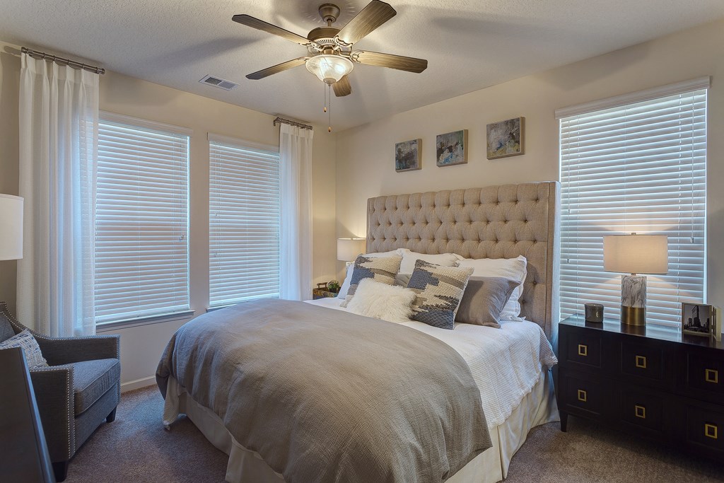 a bedroom with a large bed and a ceiling fan