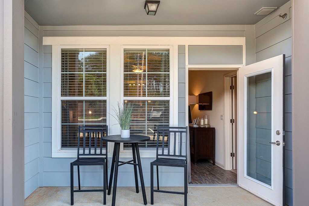 a patio with a table and chairs and a door