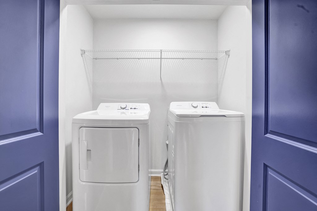 two washing machines in a room with a blue door