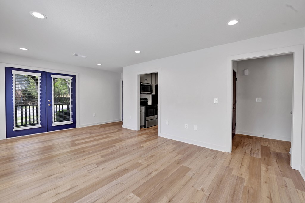 a living room with a hard wood floor and a blue door