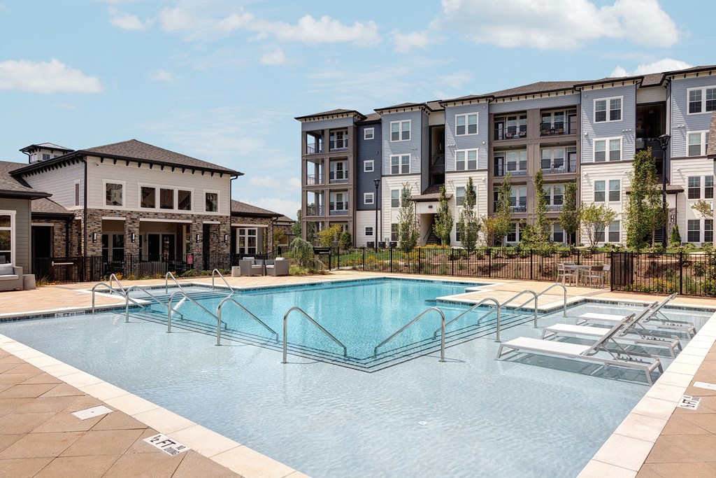 a swimming pool with an apartment building in the background