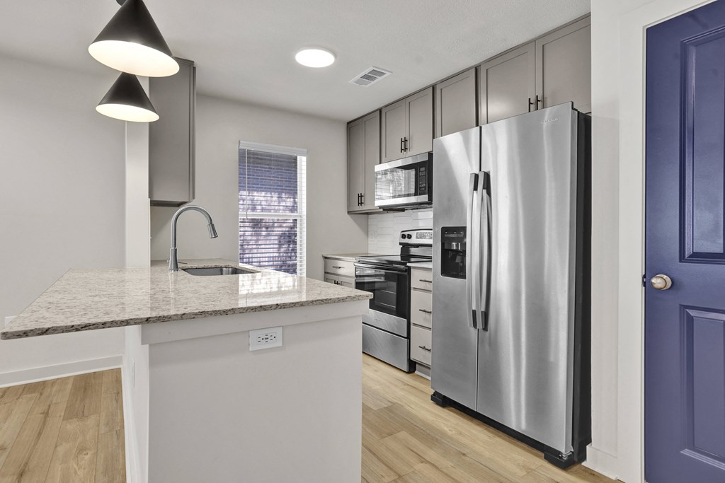 a renovated kitchen with stainless steel appliances and a counter top