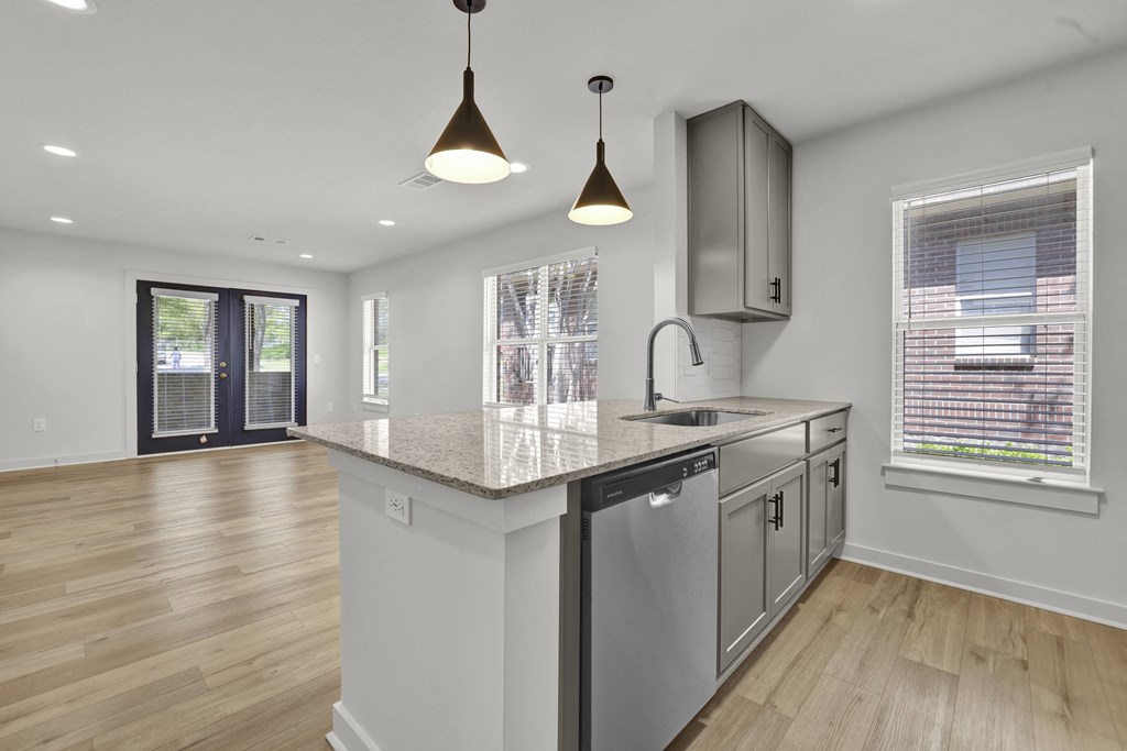 an open kitchen and living room with a large counter top