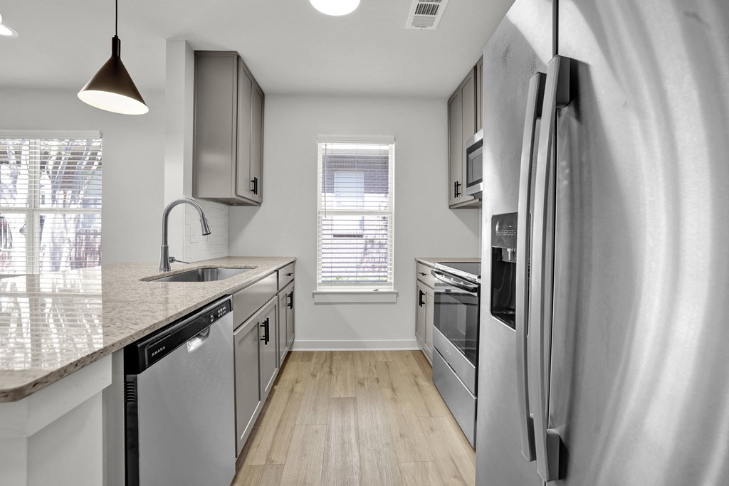 an empty kitchen with stainless steel appliances and a counter top